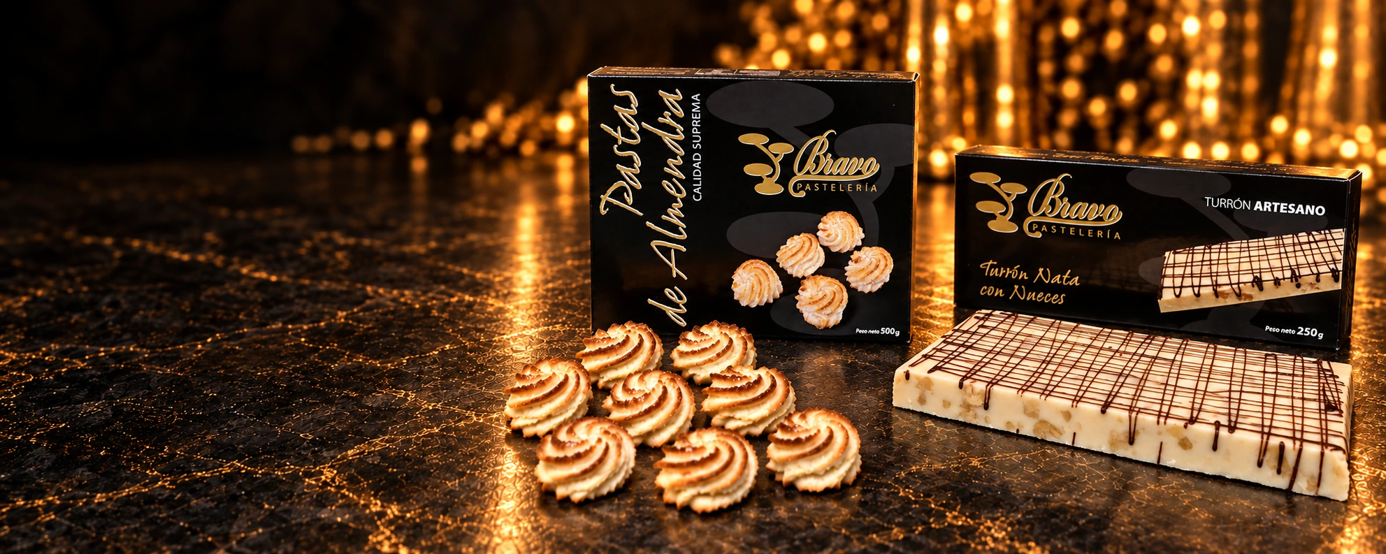 Pastas de almendra con su estuche de Pastelería Bravo y turrón de nata con nueces con su propio estuche, sobre piedra oscura con luz dorada Pastas de almendra con su estuche de Pastelería Bravo y turrón de nata con nueces con su propio estuche, sobre piedra oscura con luz dorada